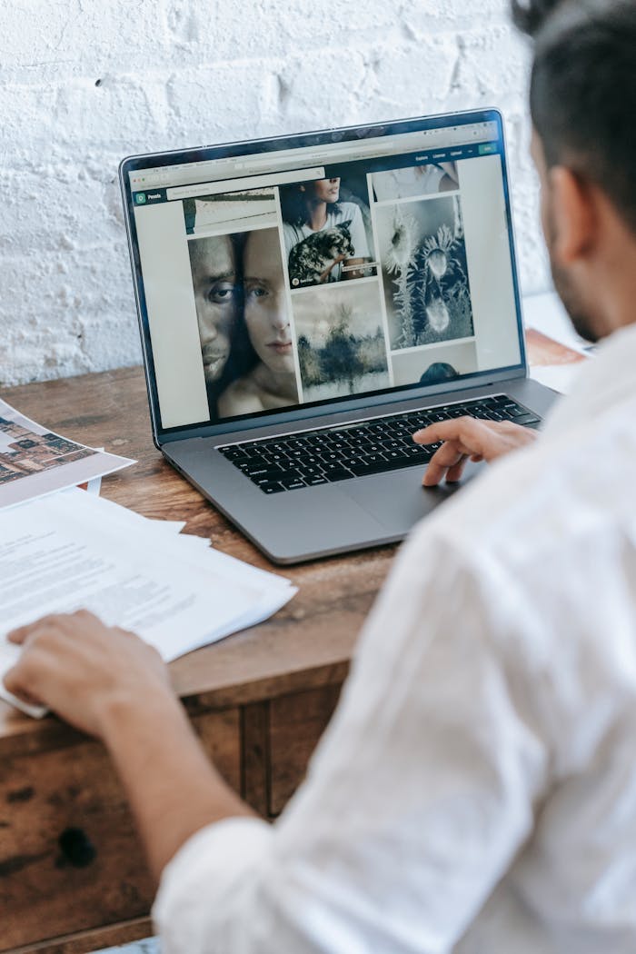 Crafting Captivating Headlines: Your awesome post title goes here Back view of crop anonymous male freelancer sitting at table and working on project on laptop in light room in daytime